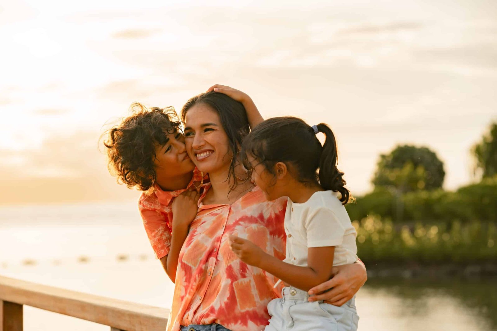 Une mère et ses deux enfants sur le ponton à la plage pendant un shooting famille à Tahiti