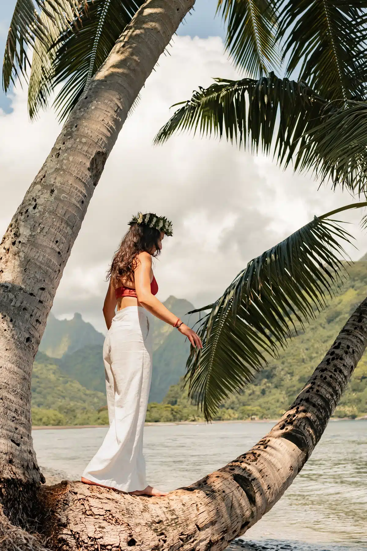 Femme se promenant sur un tronc de palmier, prise par Samantha Hemery, photographe à Tahiti