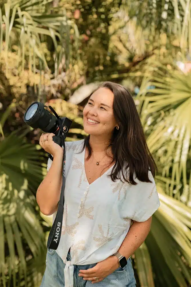 Samantha Hemery Photographe Tahiti Photographe qui prend la pose avec son appareil photo dans un parc à Tahiti